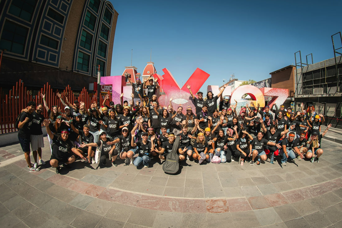 A large group of people in black t-shirts posing before a colorful city sign